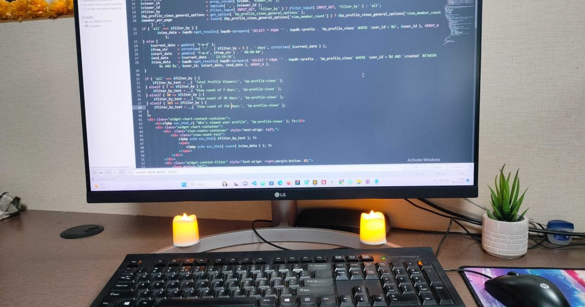 Web development: Code on screen, candles, home plant—a cozy and productive workspace ambiance