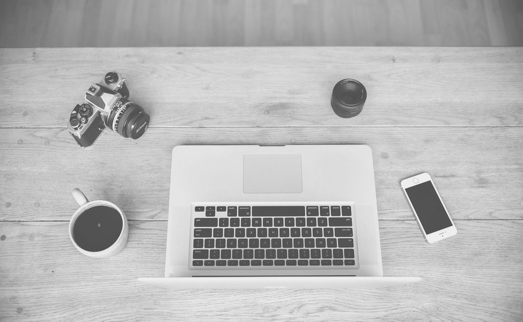 A laptop with a cup of coffee beside it