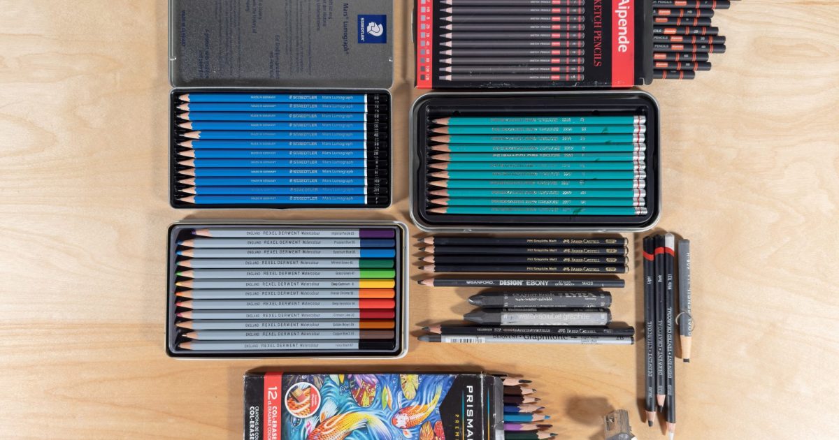 A top view photograph of several types of drawing pencils ranging from graphite, woodless pencils, matt