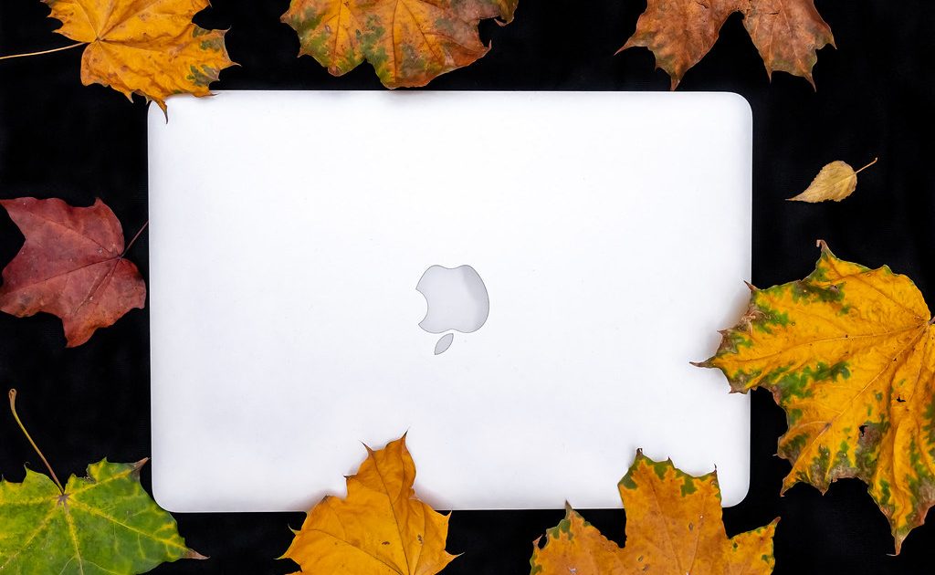 A laptop with a cup of coffee beside it