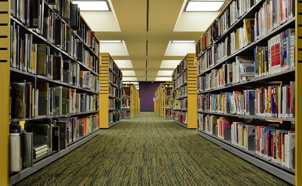 A stack of books beside a laptop