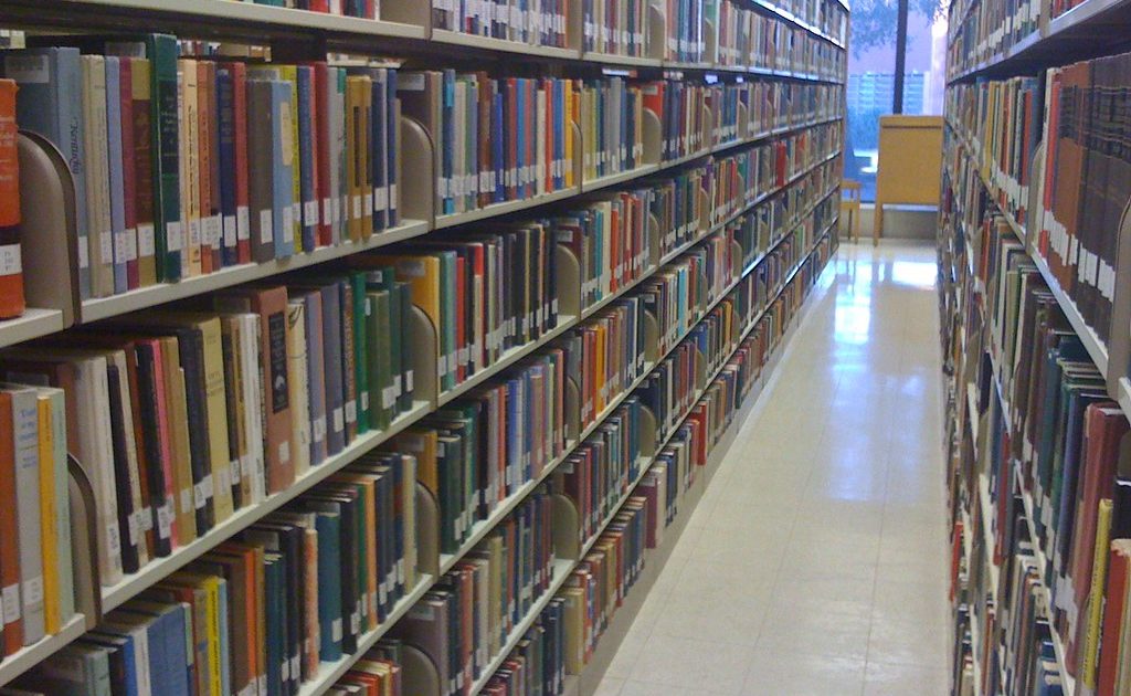 A stack of books beside a laptop