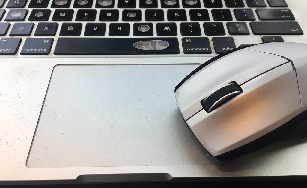 A laptop with a cup of coffee beside it