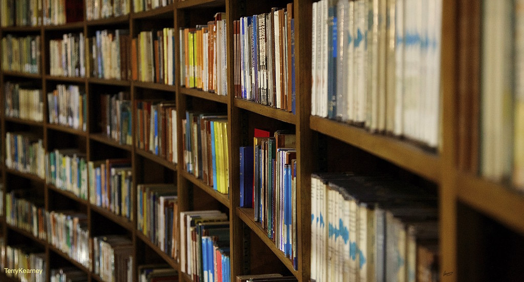 A stack of books beside a laptop