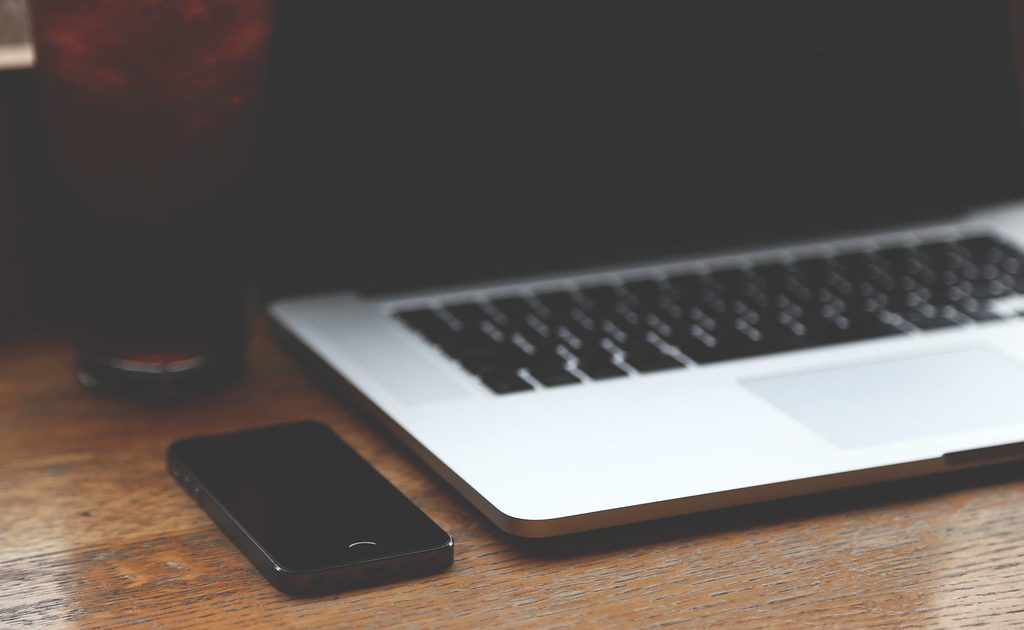 A laptop with a cup of coffee beside it