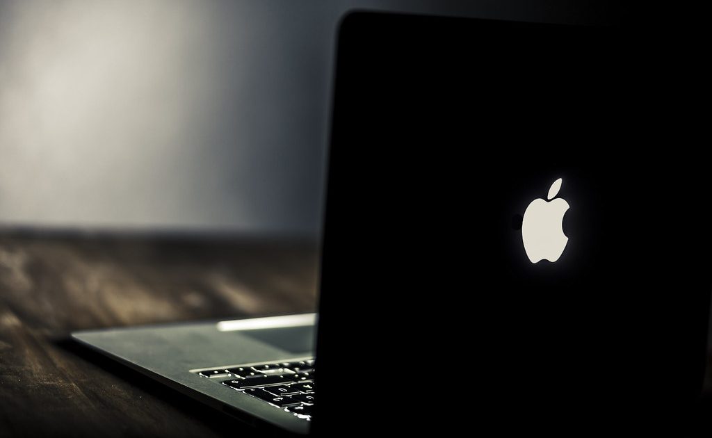 A laptop with a cup of coffee beside it