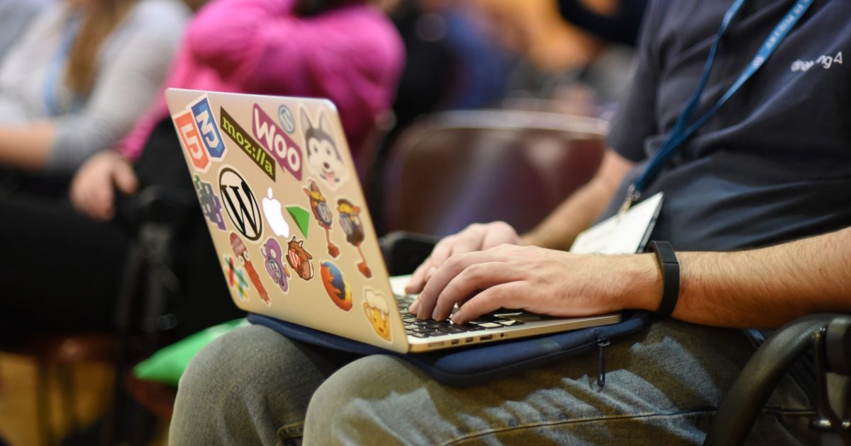 Person taking notes on a laptop at a WordCamp
